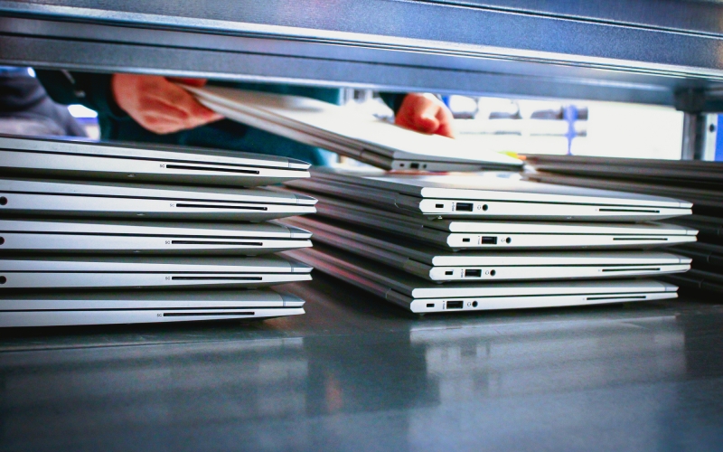  Een medewerker van Aronto pakt een gebruikte, gewiste laptop uit een schap om deze in te pakken voor verzending na aankoop door een klant.